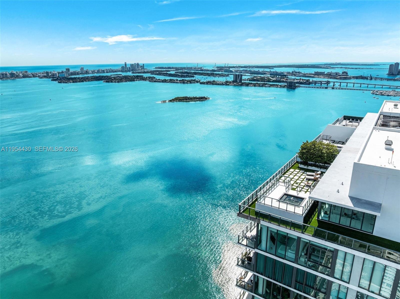 An aerial view shows a high-rise building balcony overlooking a large body of blue water — 3131 NE 7th Ave, Miami FL 33137, MIAMI, FL