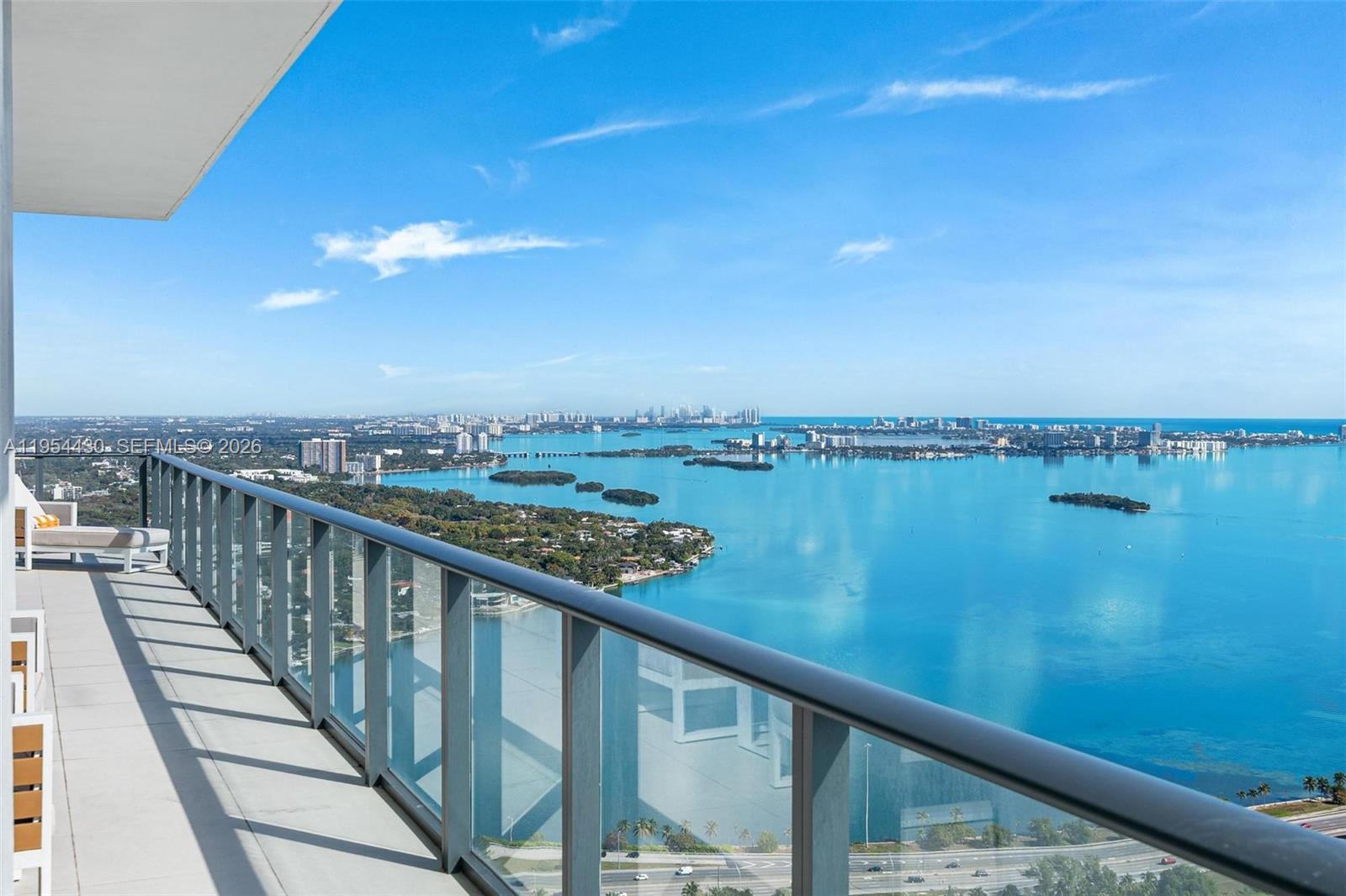 A high-rise balcony overlooks a large bay with islands and a distant city skyline — 3131 NE 7th Ave, Miami FL 33137, MIAMI, FL