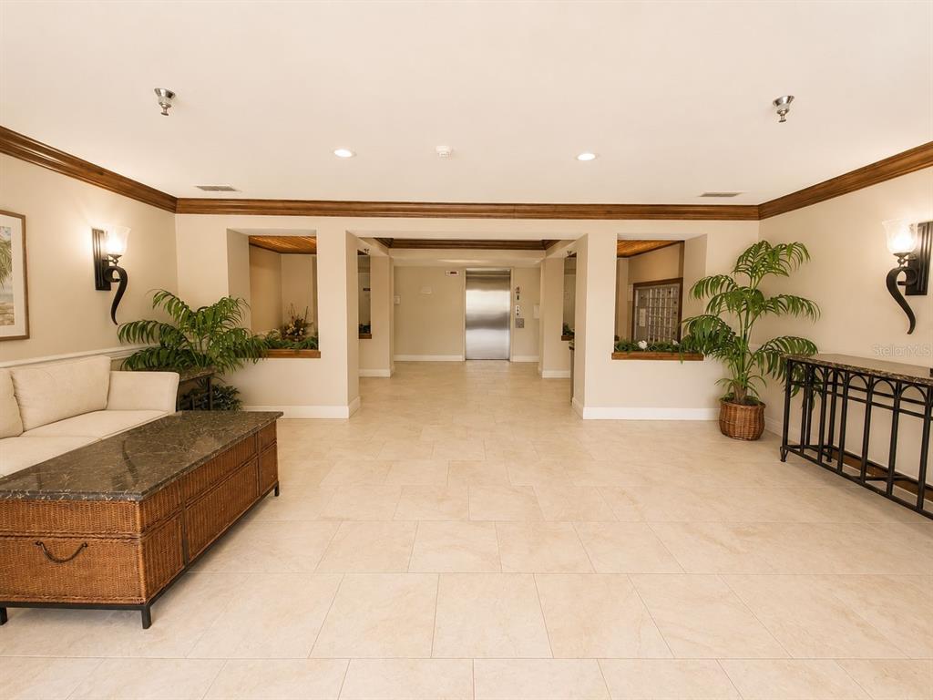 A lobby area features tile flooring, a sofa, a coffee table, and an elevator — 2323 FEATHER SOUND DRIVE UNIT 205, CLEARWATER, FL