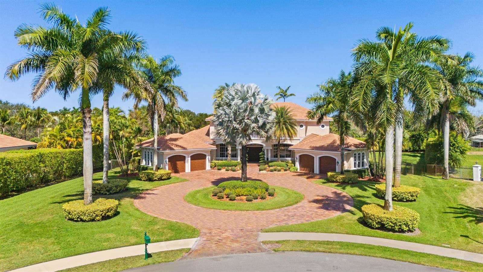 A large two-story house with a circular brick driveway and palm trees in the front yard — 12741 Kapok Lane, Davie FL 33330, DAVIE, FL