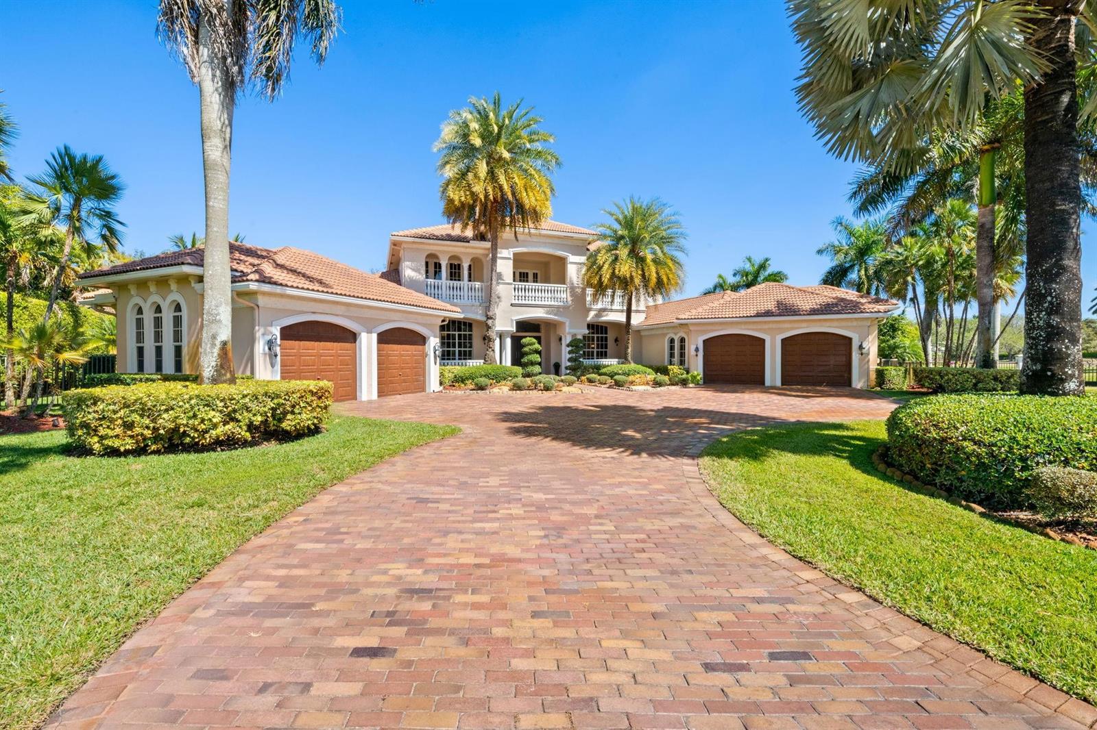 A large two-story Mediterranean-style house features a brick driveway and four garage bays — 12741 Kapok Lane, Davie FL 33330, DAVIE, FL