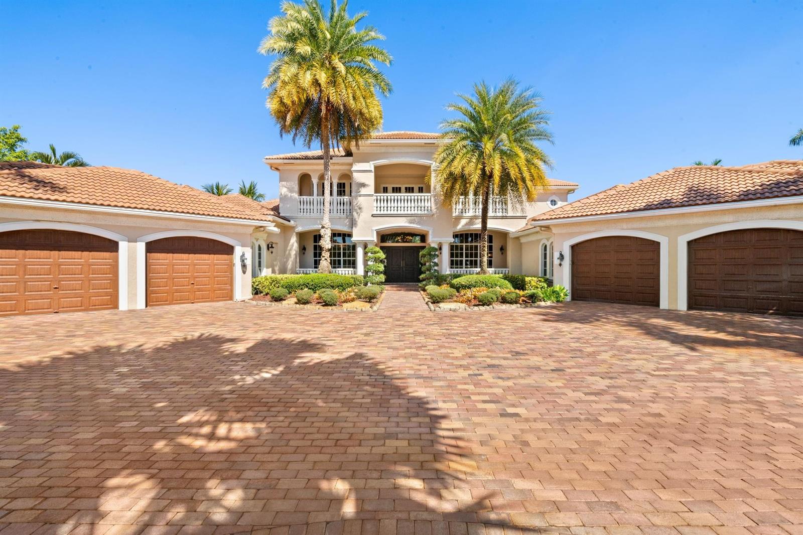 A large two-story house with a brick driveway, four garage doors, and two palm trees — 12741 Kapok Lane, Davie FL 33330, DAVIE, FL