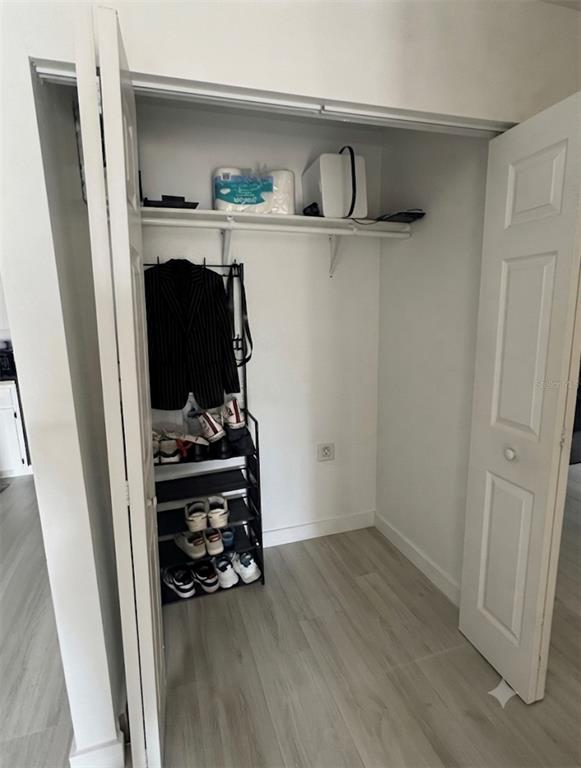A closet with a shoe rack, a hanging jacket, and a shelf with storage items — 5355 SE 29TH PLACE, OCALA, FL