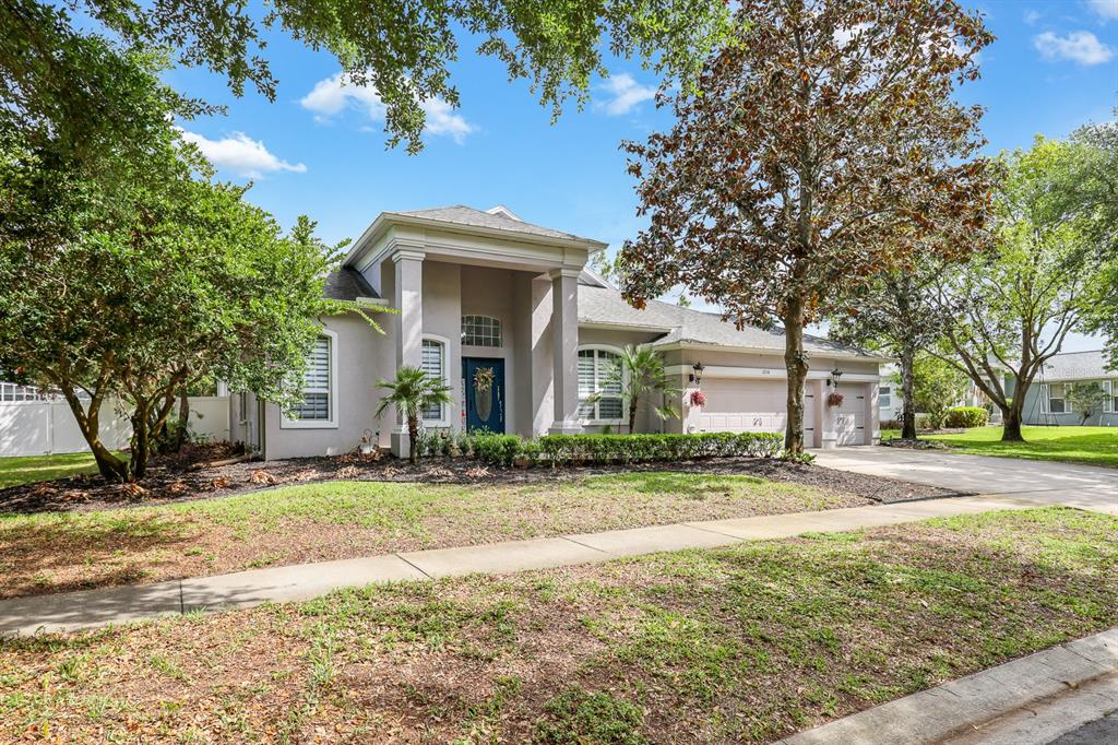 A single-story house with a covered entryway, a two-car garage, and a landscaped front yard — 12114 CREEK EDGE DRIVE, RIVERVIEW, FL
