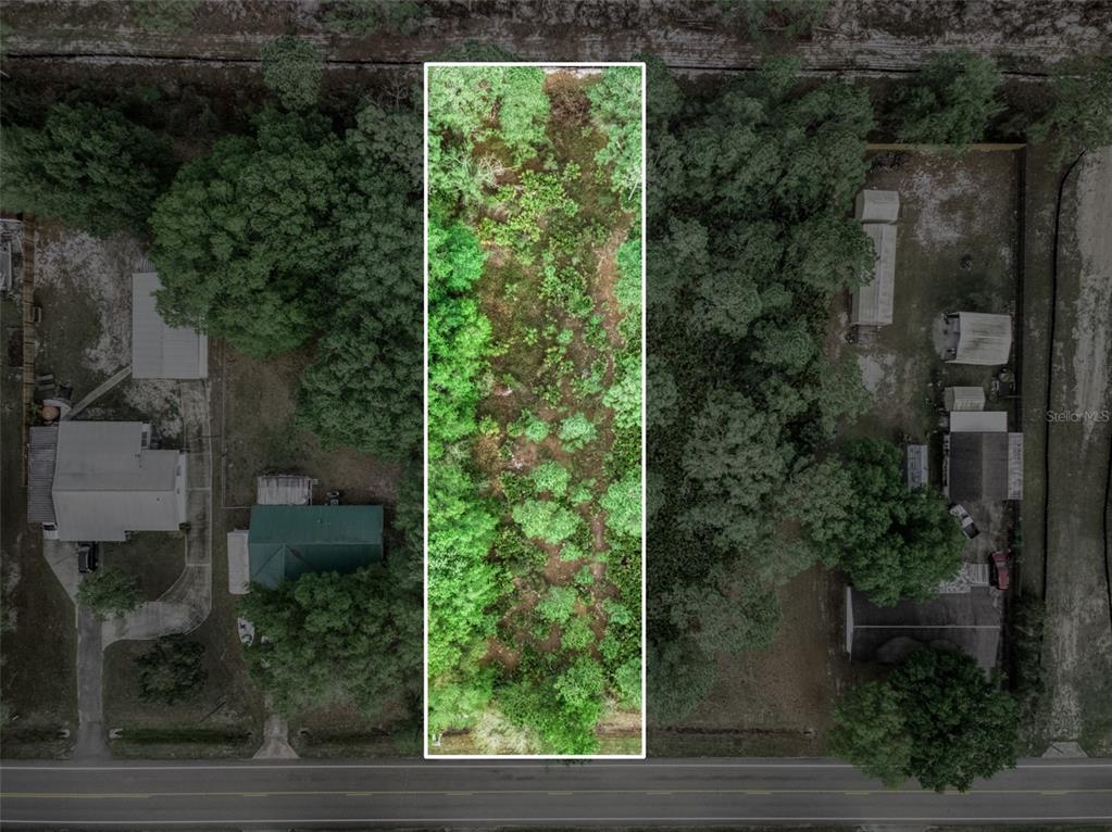 An aerial view shows a rectangular, wooded vacant lot situated between two residential properties — 4814 LAKEWOOD ROAD, SEBRING, FL