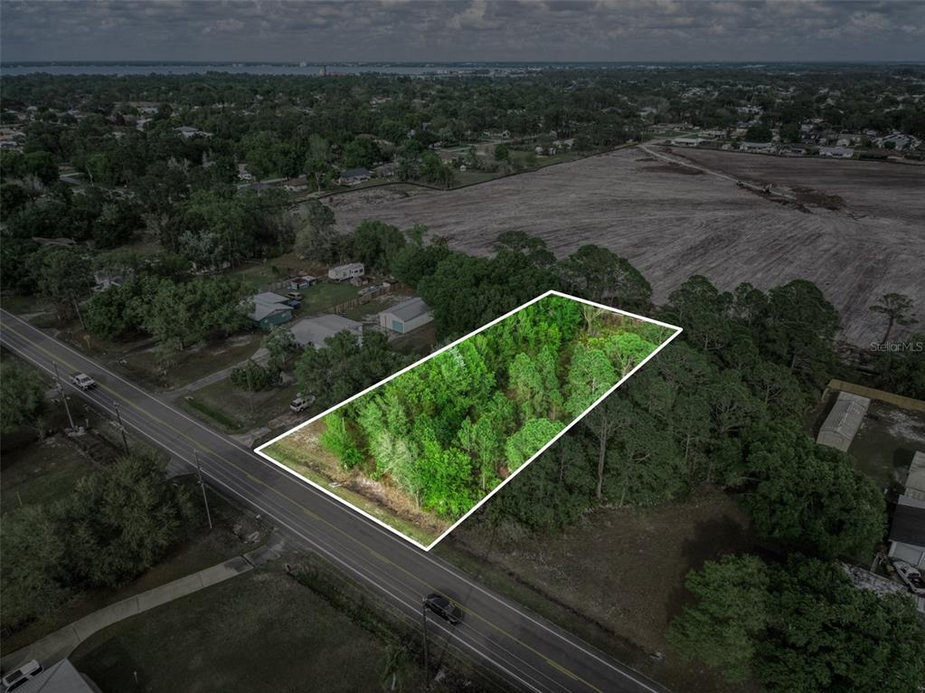 An aerial view shows a rectangular, wooded vacant lot bordered by a road and fields — 4814 LAKEWOOD ROAD, SEBRING, FL