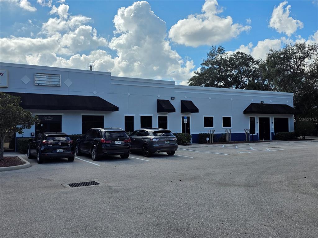 A single-story commercial building with a parking lot in front under a cloudy sky — 1400 JORDAN AVENUE UNIT 3 & 4, ORLANDO, FL