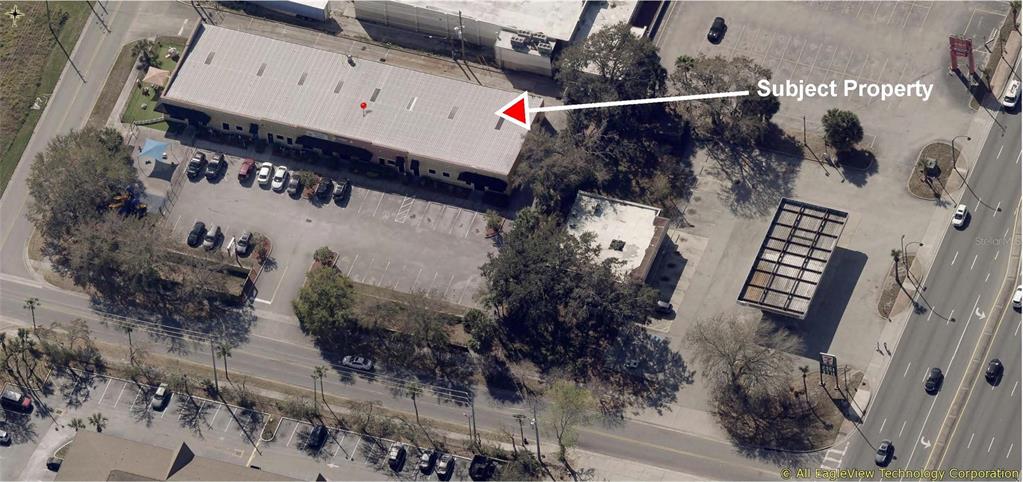 An aerial view shows a commercial building with a parking lot and surrounding trees — 1400 JORDAN AVENUE UNIT 3 & 4, ORLANDO, FL