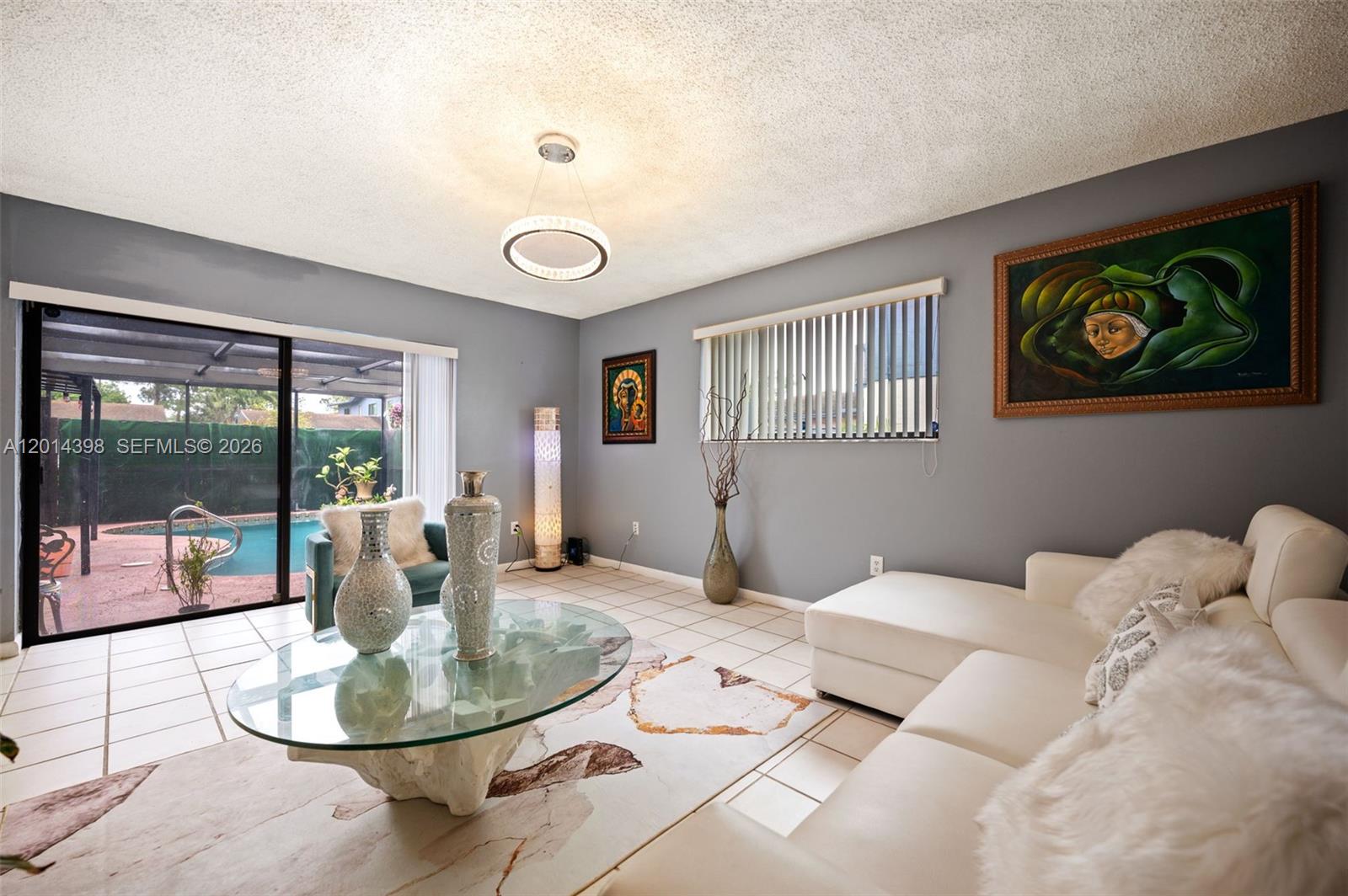 A living room features a white sectional sofa, glass coffee table, and a sliding door view — 4582 Holly Lake Dr, Lake Worth FL 33463, LAKE WORTH, FL