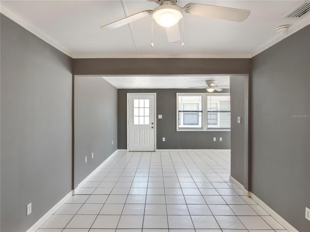 An interior view shows a room with gray walls, white tile flooring, and ceiling fans — 10301 US HIGHWAY 27 UNIT 172, CLERMONT, FL