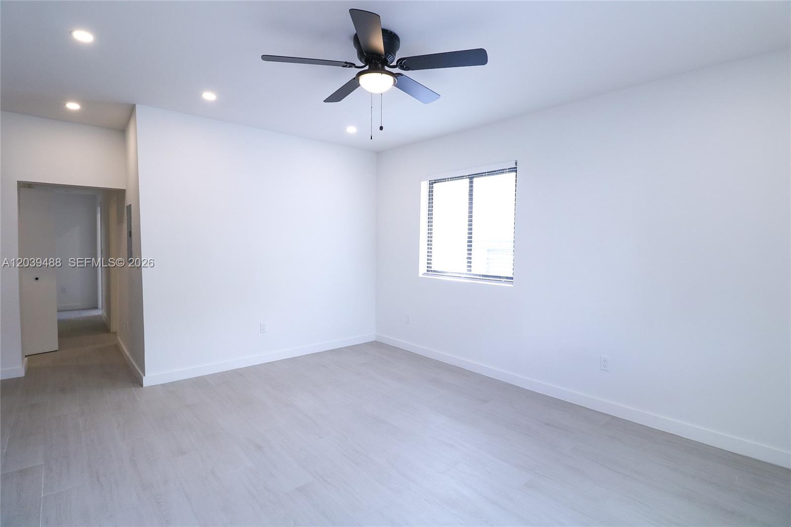 A bright, empty bedroom features white walls, light wood-look flooring, and a ceiling fan — 221 SW 11th Ave # 2, Miami FL 33130, MIAMI, FL