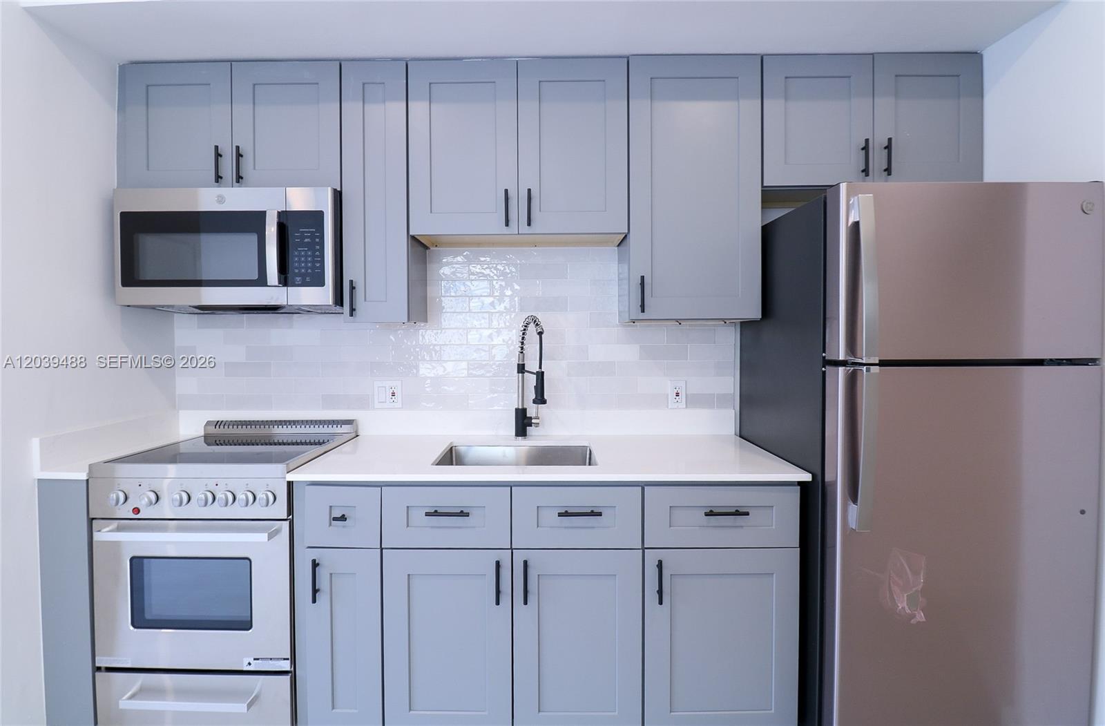 A kitchen features grey cabinets, stainless steel appliances, a white countertop, and a subway tile backsplash — 221 SW 11th Ave # 2, Miami FL 33130, MIAMI, FL