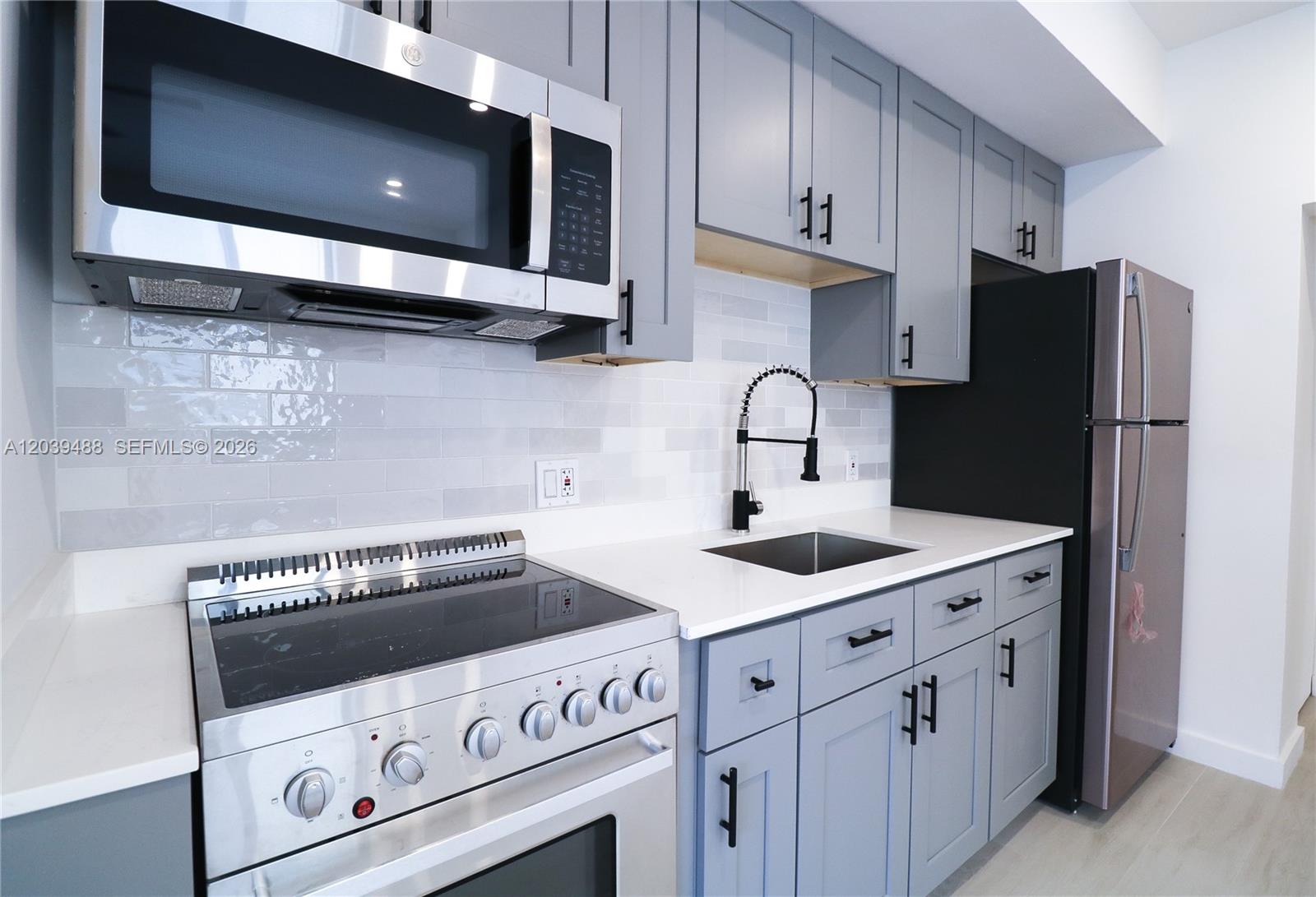 A kitchen features gray cabinets, stainless steel appliances, a white backsplash, and white countertops — 221 SW 11th Ave # 2, Miami FL 33130, MIAMI, FL