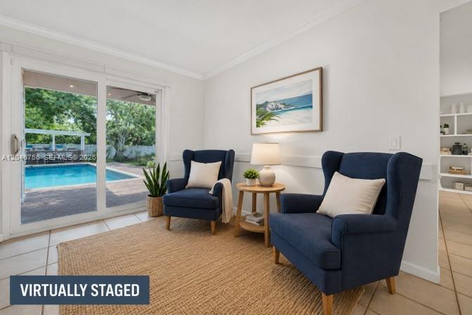 This living area features two blue armchairs, a side table, and sliding doors overlooking a pool — 14630 SW 147th Ct, Miami FL 33196, MIAMI, FL