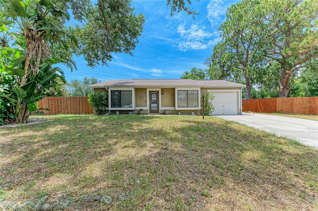 A single-story house with a tan exterior, a front-facing garage, and a fenced yard — 2226 LOCKWOOD MEADOWS DRIVE, SARASOTA, FL