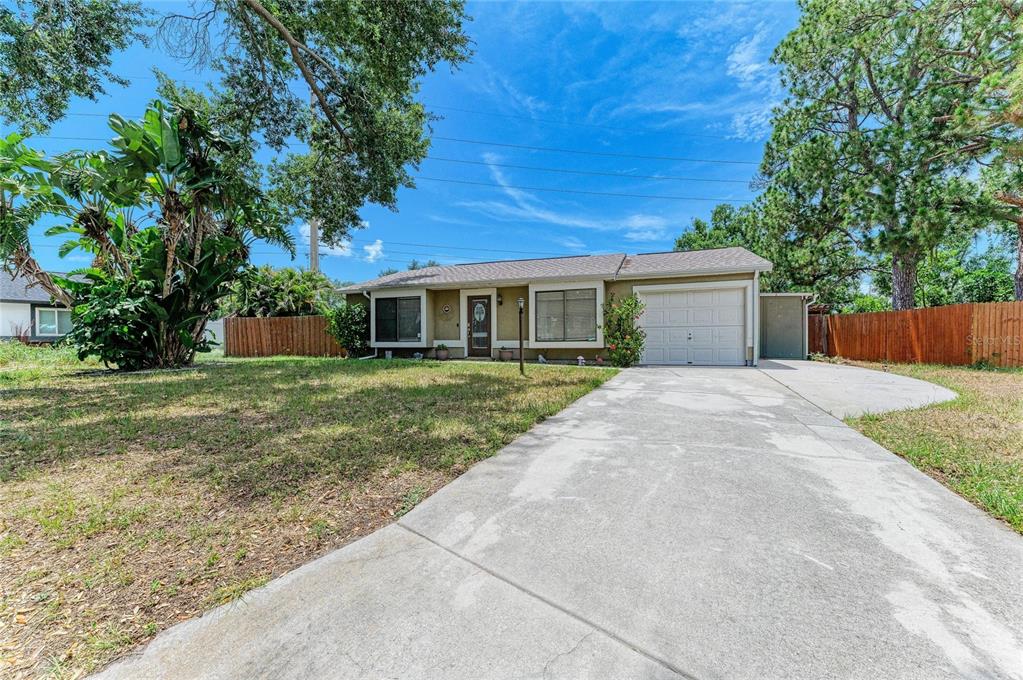A single-story house with a concrete driveway, a one-car garage, and a large front yard — 2226 LOCKWOOD MEADOWS DRIVE, SARASOTA, FL
