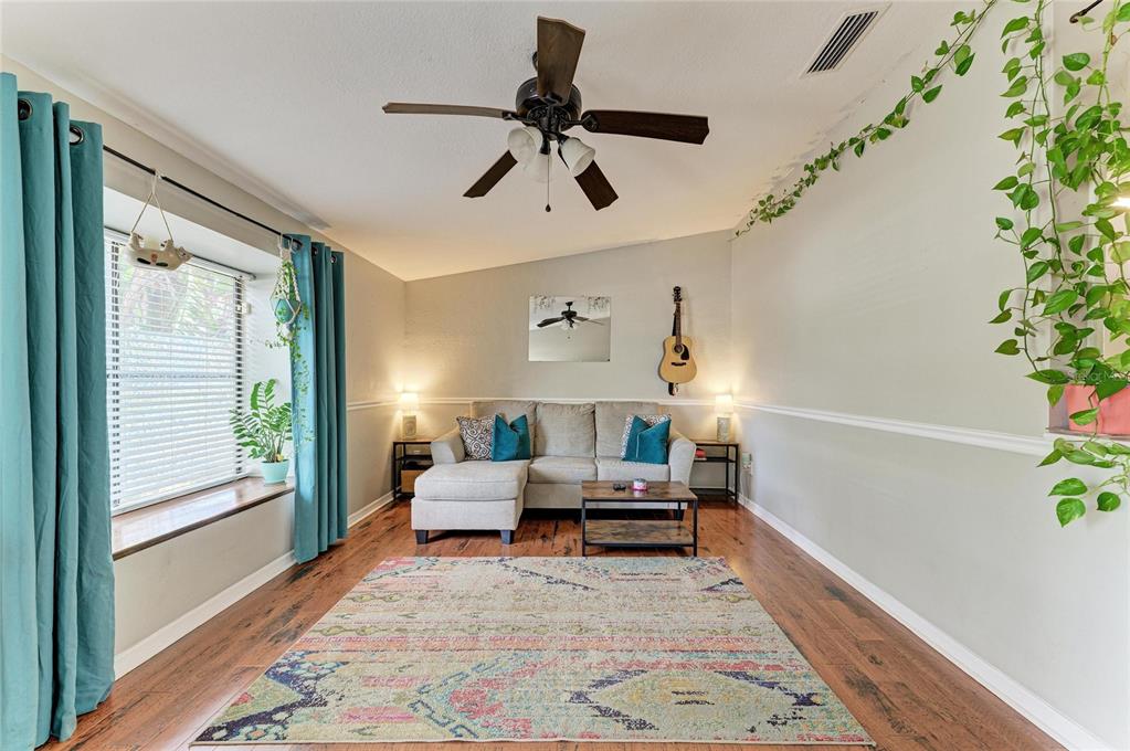 A living room features a sectional sofa, a patterned area rug, and a ceiling fan — 2226 LOCKWOOD MEADOWS DRIVE, SARASOTA, FL