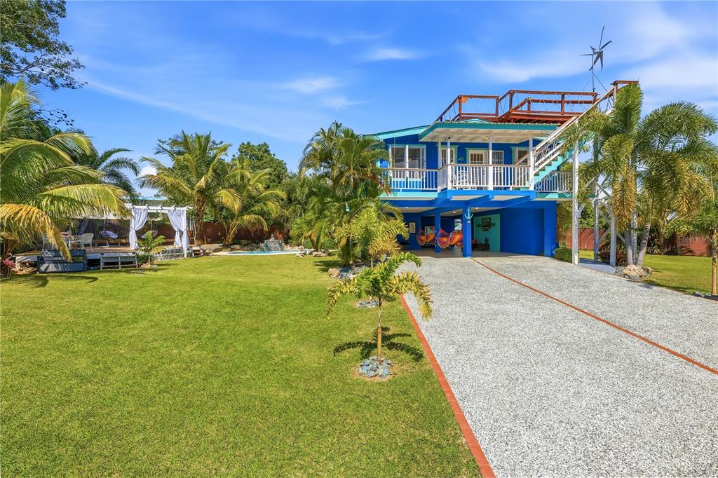 A blue elevated house features a gravel driveway, a rooftop deck, and a backyard pool — 1/1A GIL BOUYET STREET, CABO ROJO, PR