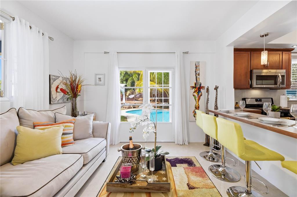 A living room with a sofa and coffee table opens to a patio with a pool — 1/1A GIL BOUYET STREET, CABO ROJO, PR