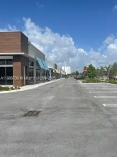 A view of a modern commercial building exterior with a parking lot under a blue sky — 10890 NW 17 TH ST # 128, Miami 00172, MIAMI, FL