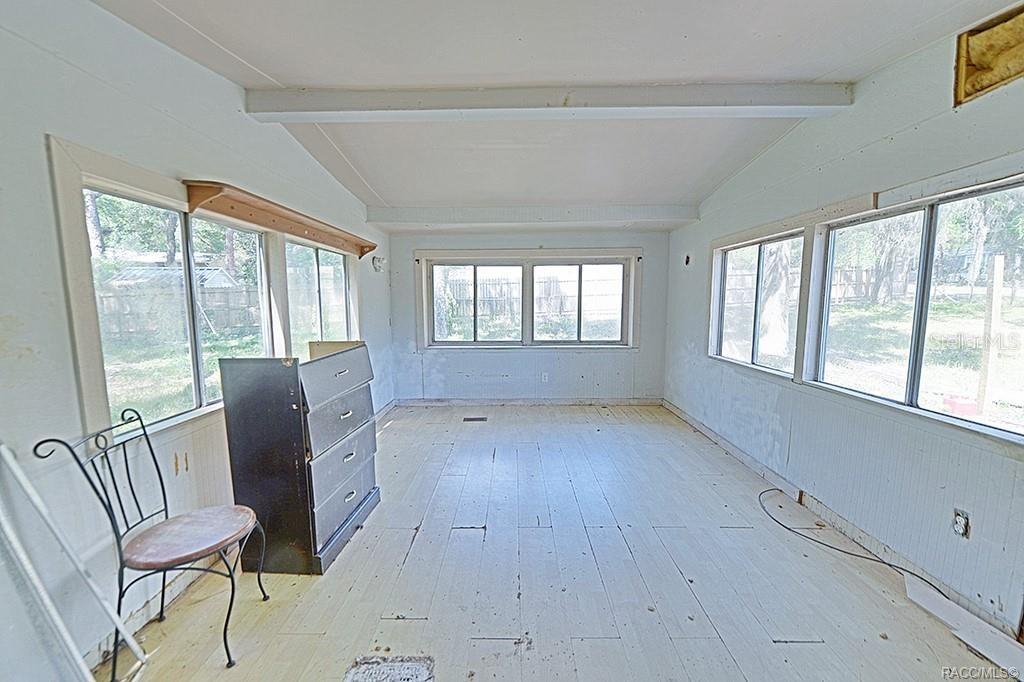 A sunroom with white wood-plank flooring, light-colored walls, and large windows on three sides — 5332 E SOUTH CROSSING COURT, INVERNESS, FL