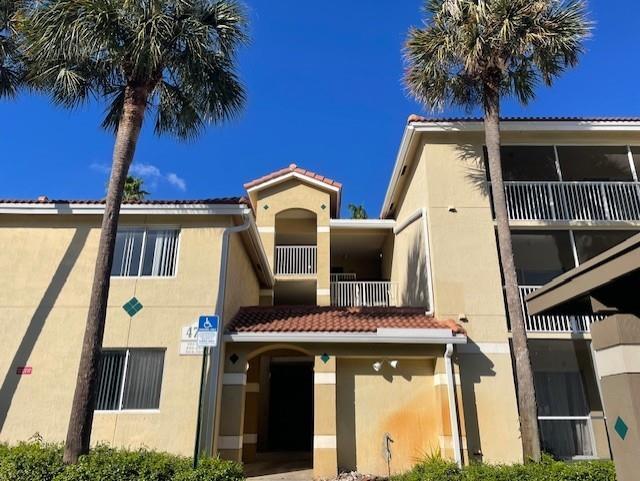 A multi-story apartment building with tan stucco walls, a tiled roof, and two palm trees — 470 S Park Road # 302, Hollywood FL 33021, HOLLYWOOD, FL