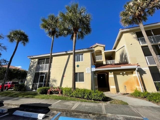A multi-story apartment building with beige stucco walls, palm trees, and a blue sky — 470 S Park Road # 302, Hollywood FL 33021, HOLLYWOOD, FL