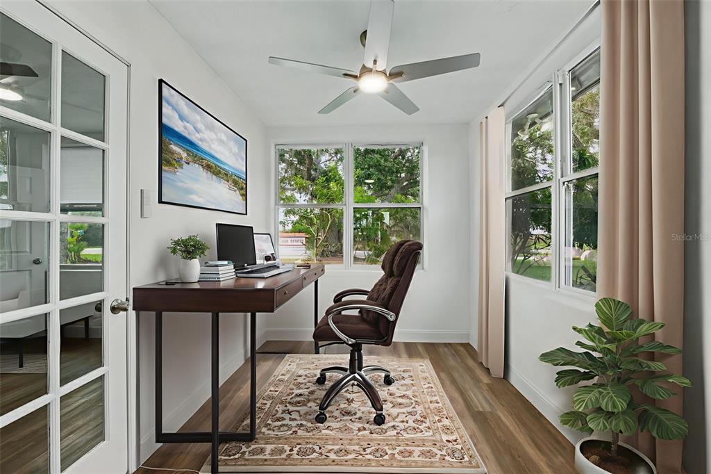 A home office features a wooden desk, an ergonomic chair, and a ceiling fan — 8812 OAKWOOD DRIVE, LAKE WALES, FL