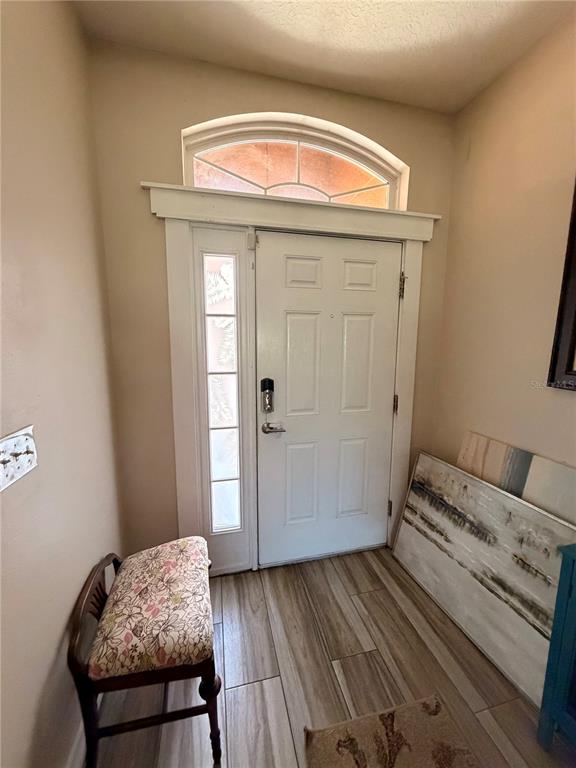 An entryway features a white front door with a sidelight, arched transom, and tile flooring — 308 CORBETT BLUFF DRIVE, RUSKIN, FL
