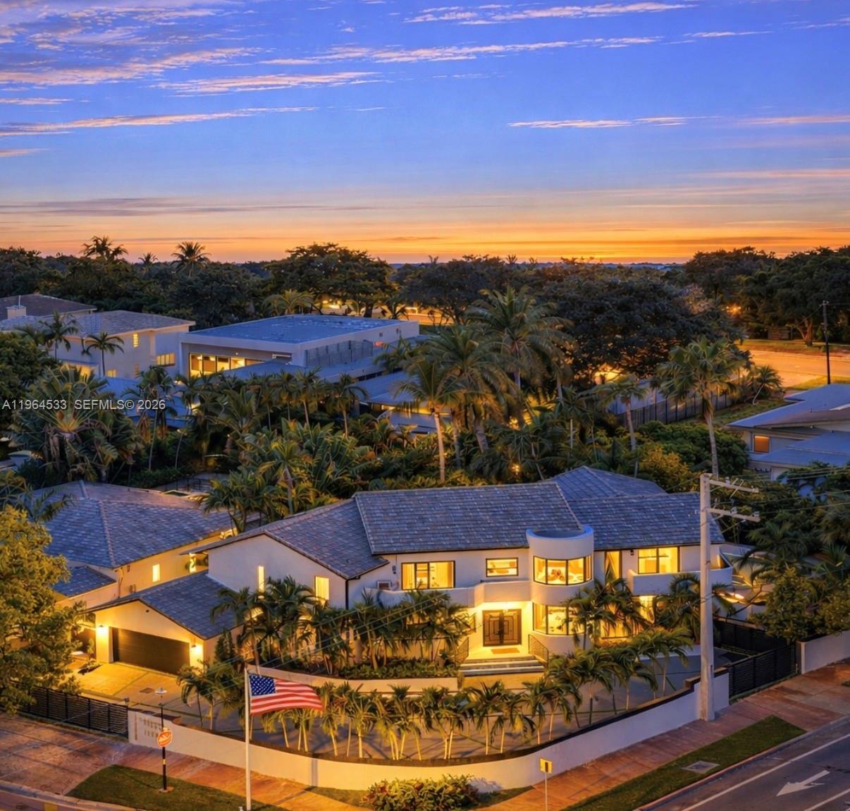 A modern two-story house exterior at night with palm trees and illuminated entry steps — 6180 Pine Tree Dr, Miami Beach FL 33140, MIAMI BEACH, FL