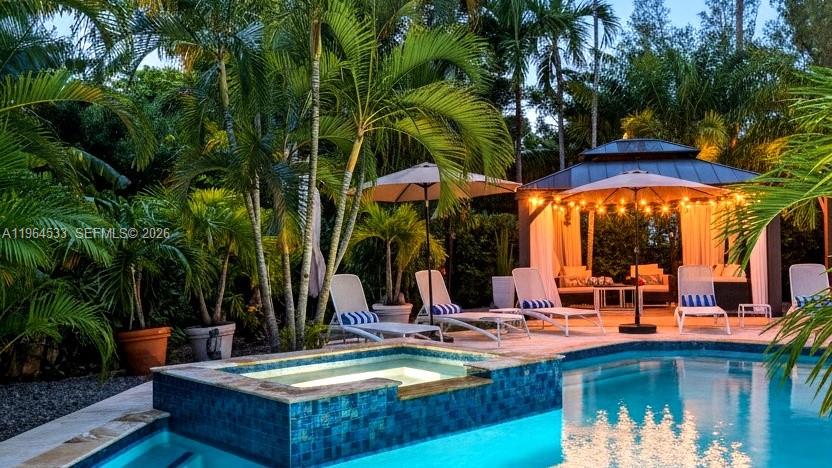 A modern white house is enclosed by a dark horizontal slat gate and perimeter wall — 6180 Pine Tree Dr, Miami Beach FL 33140, MIAMI BEACH, FL