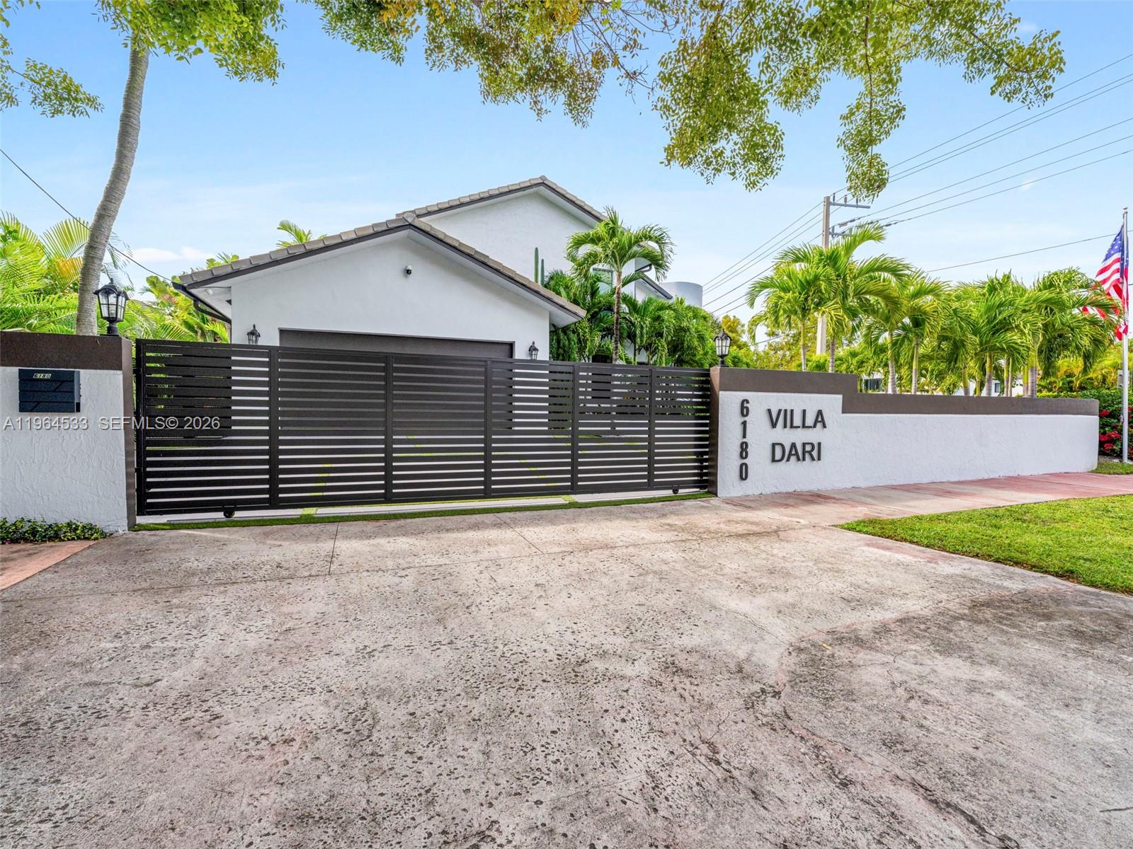 A white two-story house with a curved tower and a geometric concrete driveway — 6180 Pine Tree Dr, Miami Beach FL 33140, MIAMI BEACH, FL