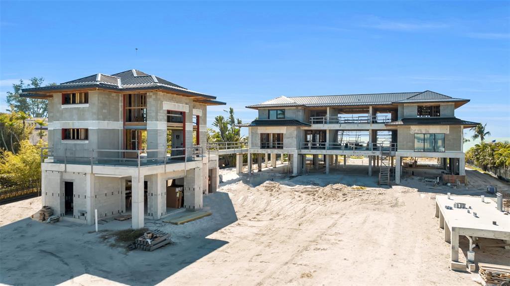 Two unfinished concrete structures stand on a sandy lot under a clear blue sky — 5965 GULF OF MEXICO DRIVE, LONGBOAT KEY, FL