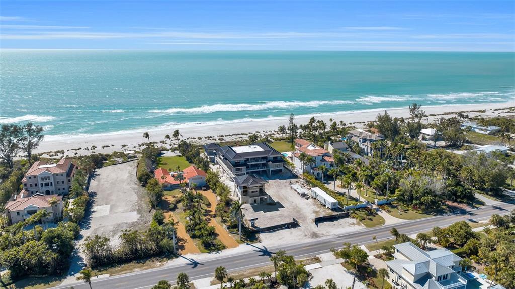 An aerial view shows a coastal property with a large house under construction near beach — 5965 GULF OF MEXICO DRIVE, LONGBOAT KEY, FL