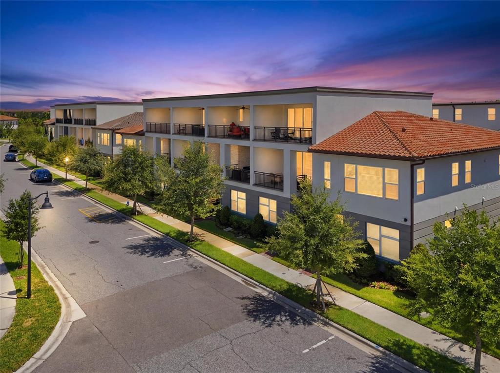 An exterior view of a multi-story apartment building with balconies and a tiled roof — 13623 LARKTON LANE, ORLANDO, FL