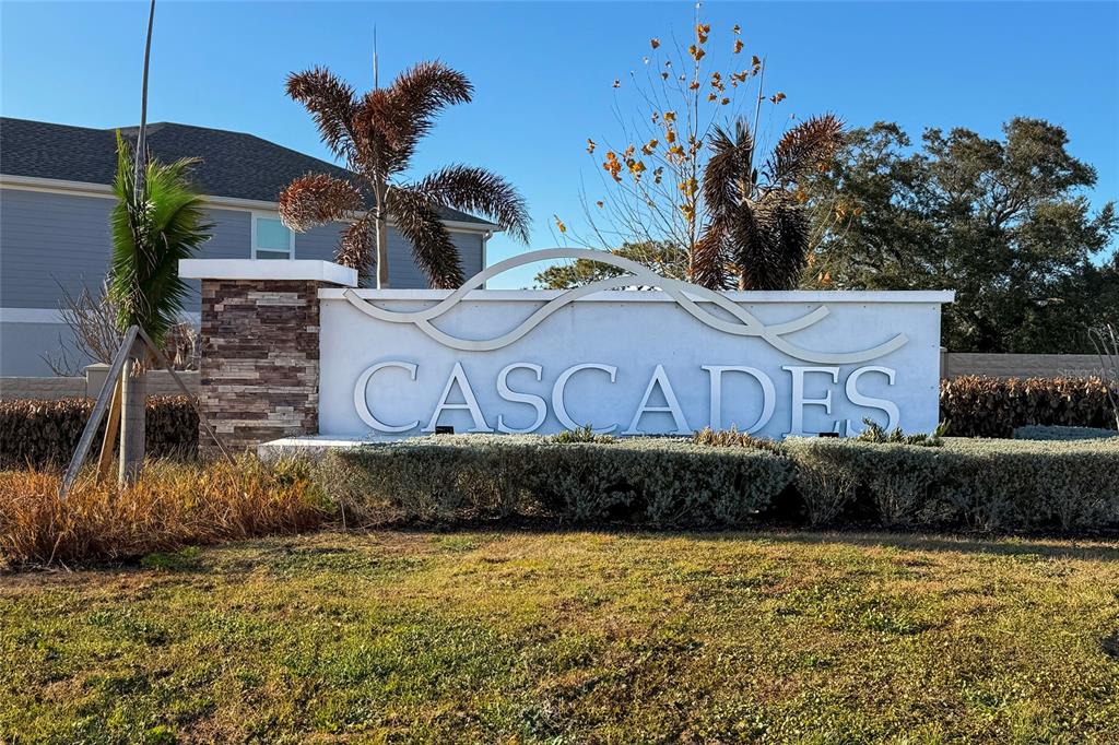 A white monument sign with the word Cascades stands in front of a residential building — 2815 MOULIN ROAD, DAVENPORT, FL