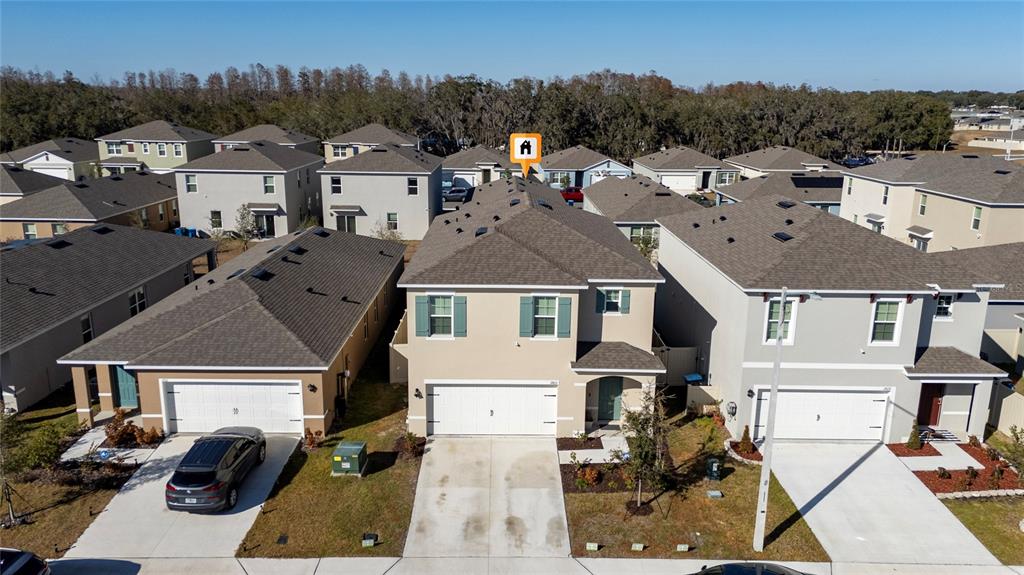 An aerial view shows a two-story tan house with a garage and a shingled roof — 2815 MOULIN ROAD, DAVENPORT, FL