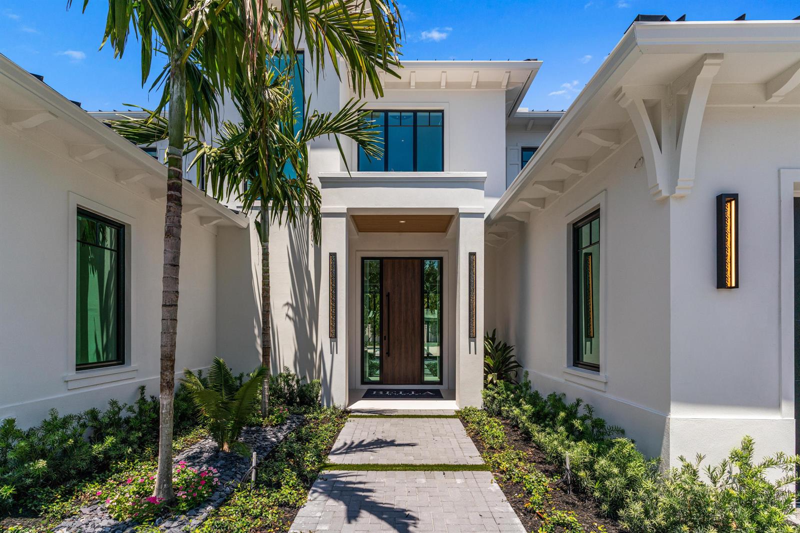 A modern white house features a wooden front door, palm trees, and a stone walkway — 720 NW 3rd Avenue, Delray Beach FL 33444, DELRAY BEACH, FL
