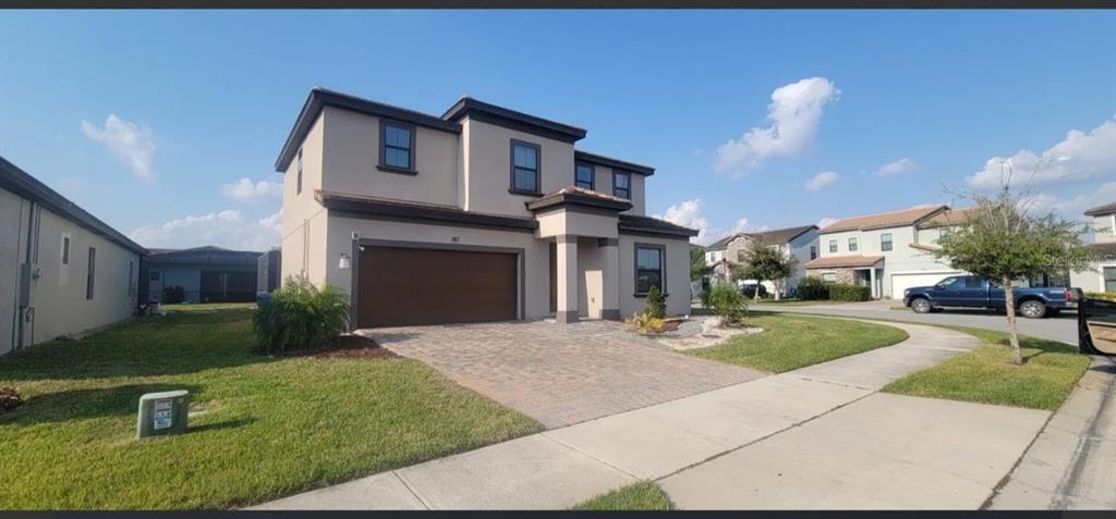A two-story suburban house with a brown garage door and a paved driveway — 187 BROOKES PLACE, HAINES CITY, FL