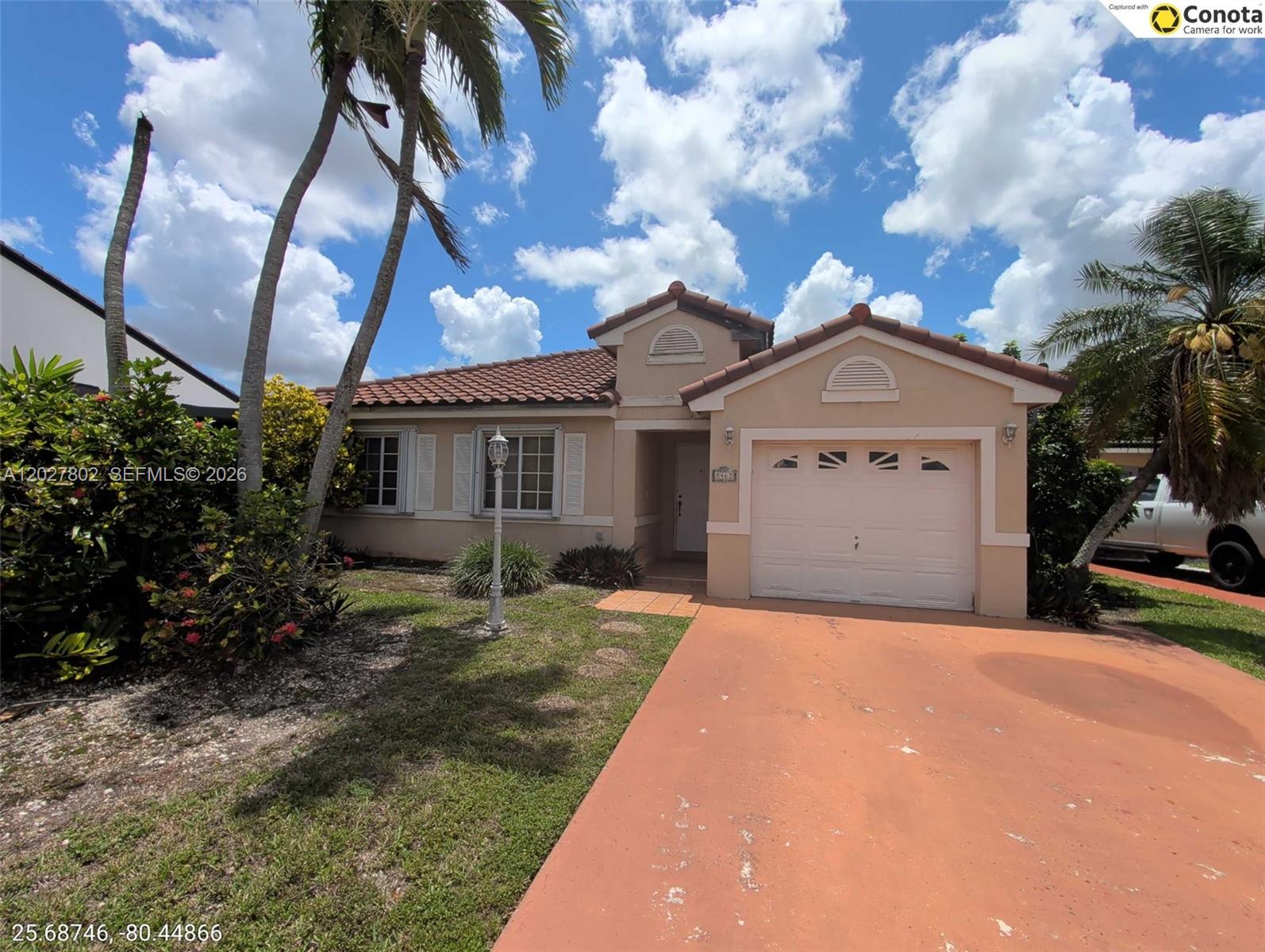 A single-story house with a tiled roof, a one-car garage, and a palm-lined front yard — 8462 SW 158th Ct, Miami FL 33193, MIAMI, FL