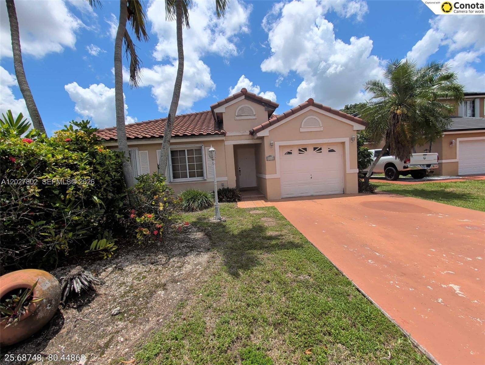 A single-story house with a terracotta tile roof, beige stucco walls, and a driveway — 8462 SW 158th Ct, Miami FL 33193, MIAMI, FL