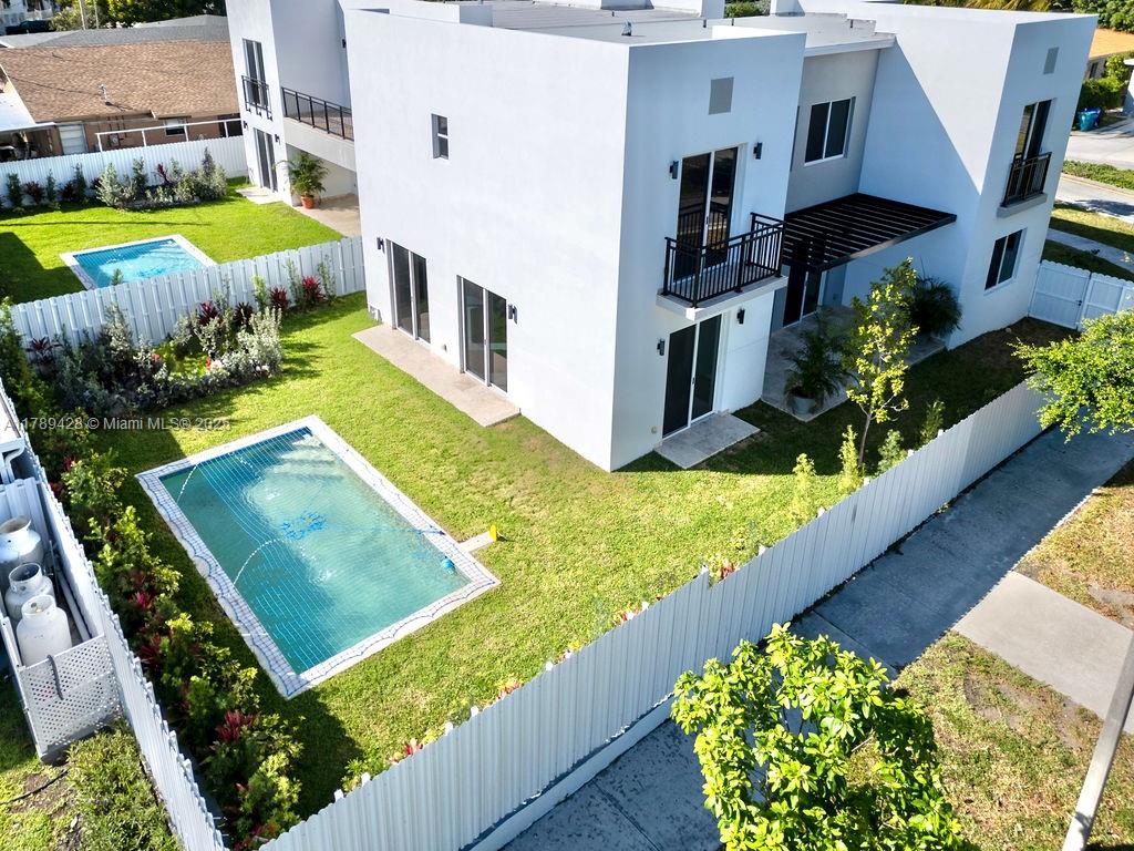 An aerial view shows a modern white house with a backyard pool and lawn — 900 SW 24th Rd, Miami FL 33129, MIAMI, FL