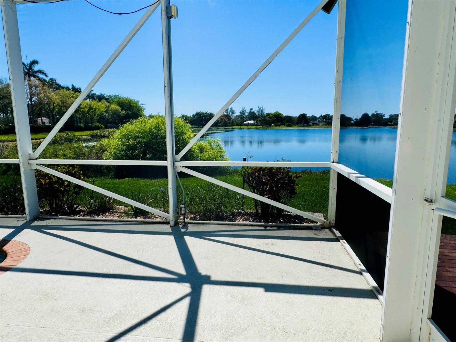 A view of a lake from a screened-in patio with a concrete floor — 9360 Cove Point Circle, Boynton Beach FL 33472, BOYNTON BEACH, FL