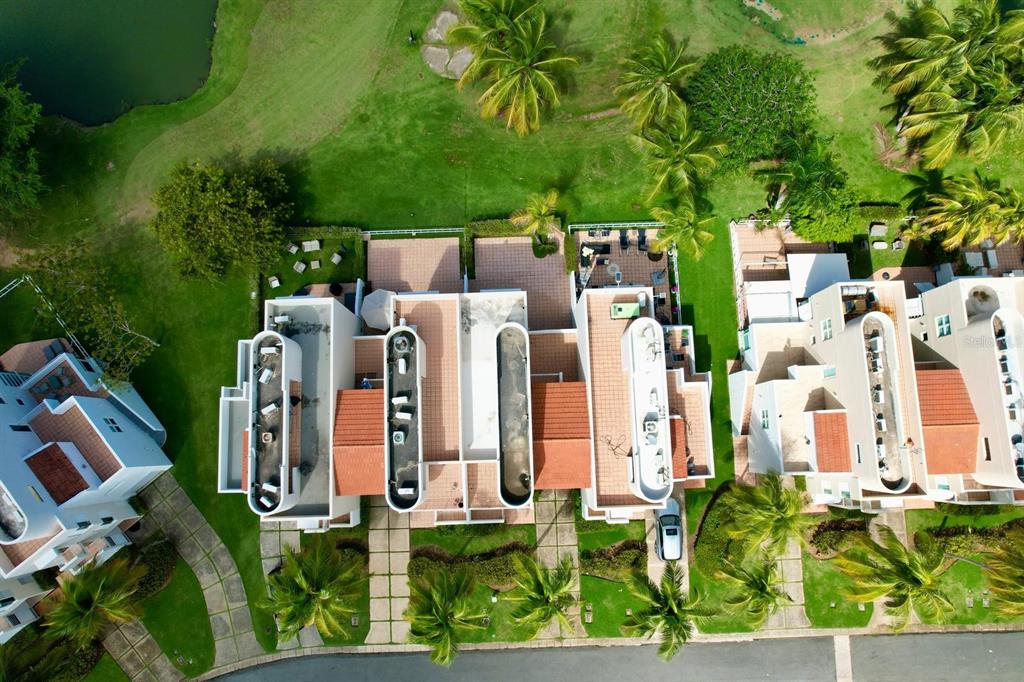 An aerial view shows a row of townhouses with tiled roofs surrounded by palm trees — #124 VILLAS DE GOLF OESTE, DORADO, PR