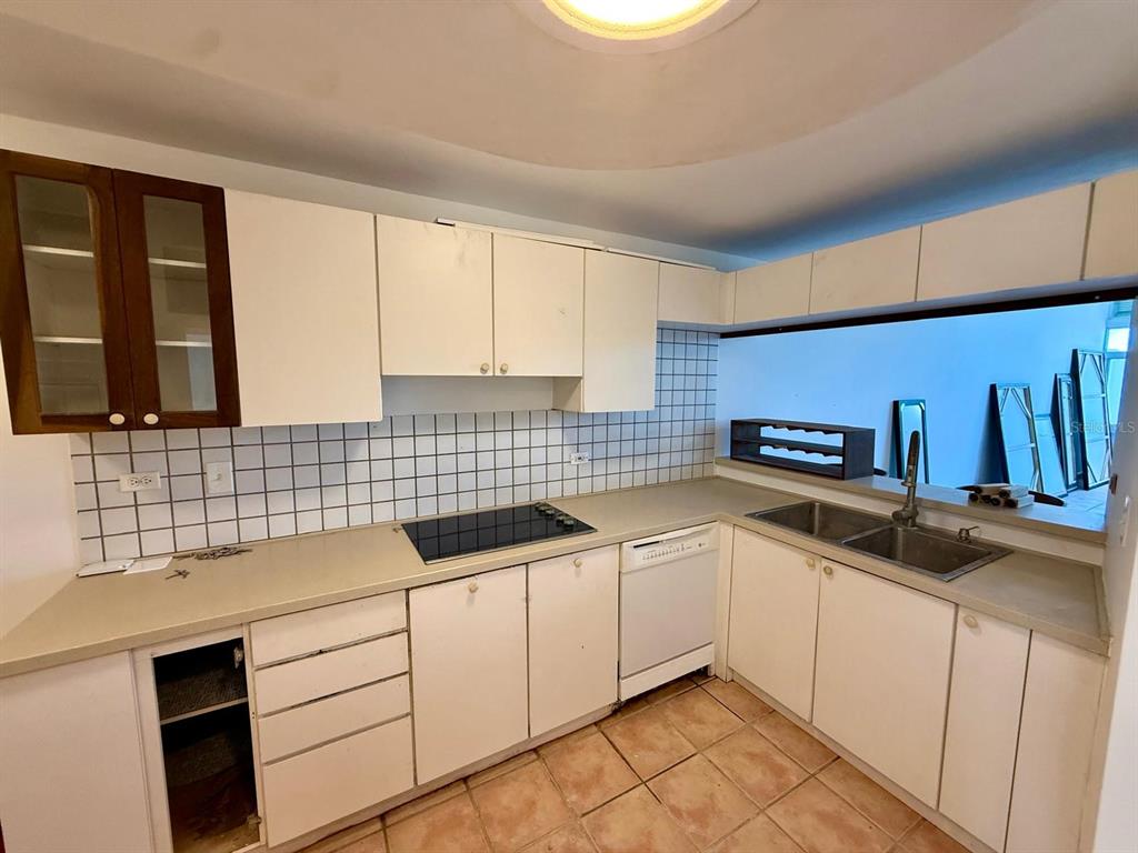 A kitchen with white cabinets, a tiled backsplash, a cooktop, and a double sink — #124 VILLAS DE GOLF OESTE, DORADO, PR