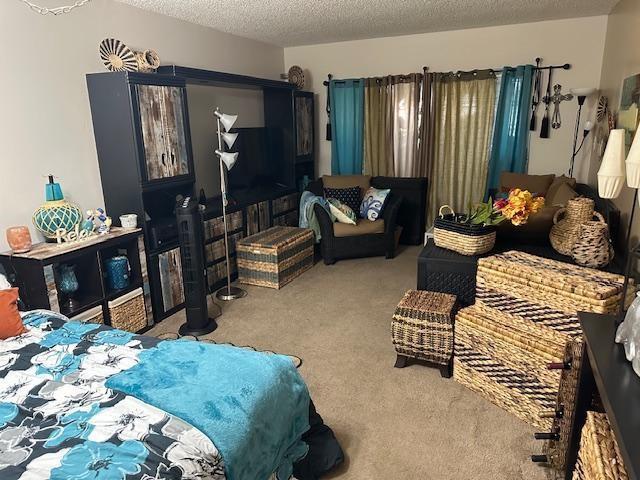 A bedroom features a large dark entertainment center, a bed with blue bedding, and woven storage — 611 S State Road 7 # 2e, Margate FL 33068, MARGATE, FL