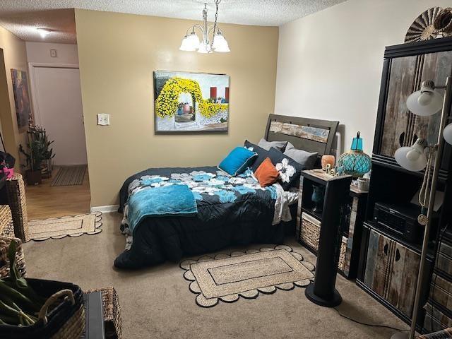A bedroom features a bed with a floral comforter, a wall painting, and a tall cabinet — 611 S State Road 7 # 2e, Margate FL 33068, MARGATE, FL