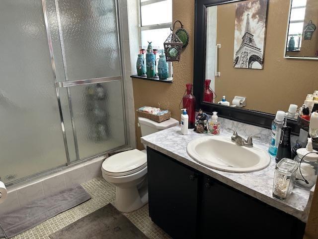 A bathroom features a glass-enclosed shower, a toilet, and a vanity with a marble-look countertop — 611 S State Road 7 # 2e, Margate FL 33068, MARGATE, FL