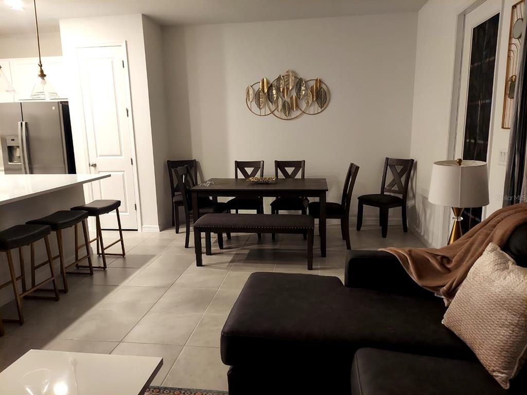 A dining area with a dark wood table, chairs, and bench sits next to a kitchen — 804 LONGBOAT DRIVE UNIT 804, DAVENPORT, FL