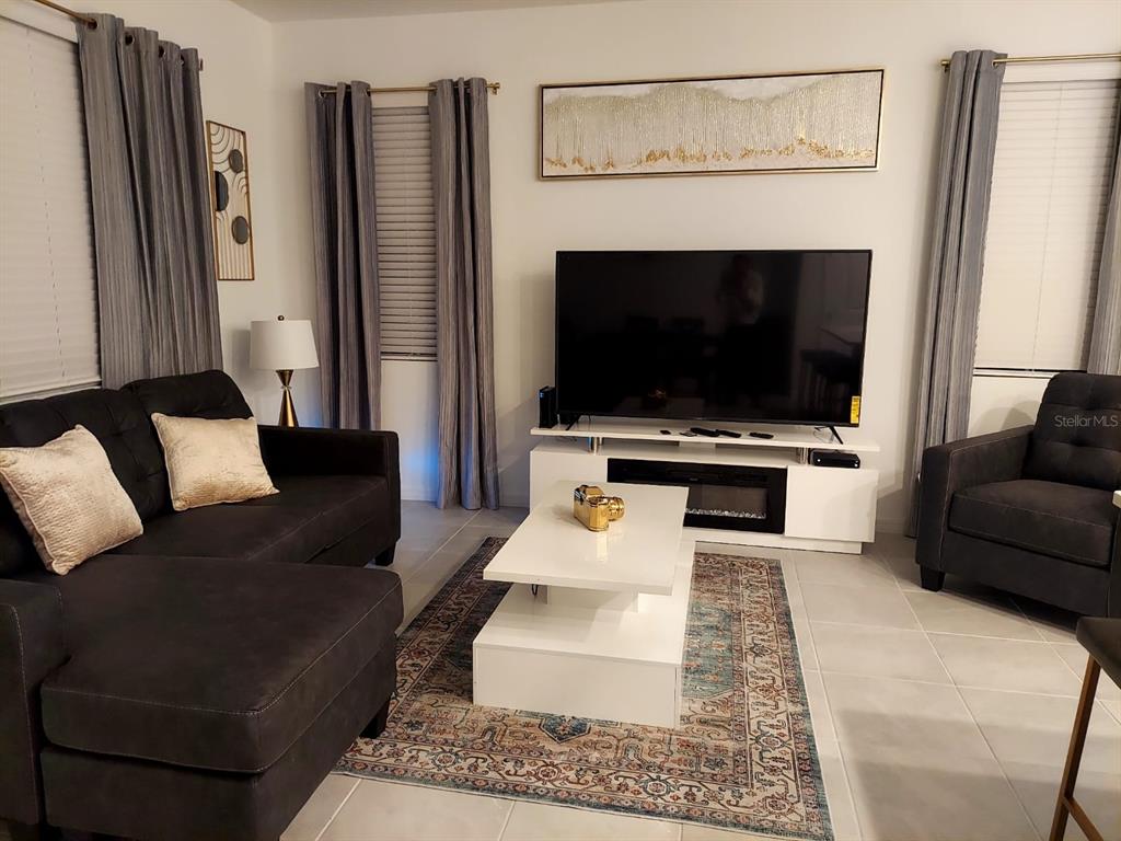 A living room features a dark sectional sofa, a white coffee table, and a television — 804 LONGBOAT DRIVE UNIT 804, DAVENPORT, FL